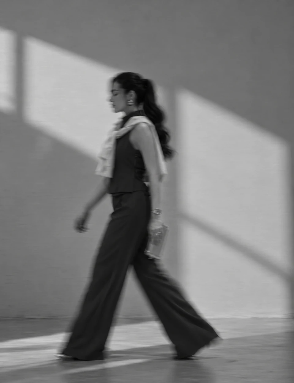 Sabrina Reis caminhando em fotografia editorial em preto e branco, com efeito de movimento.